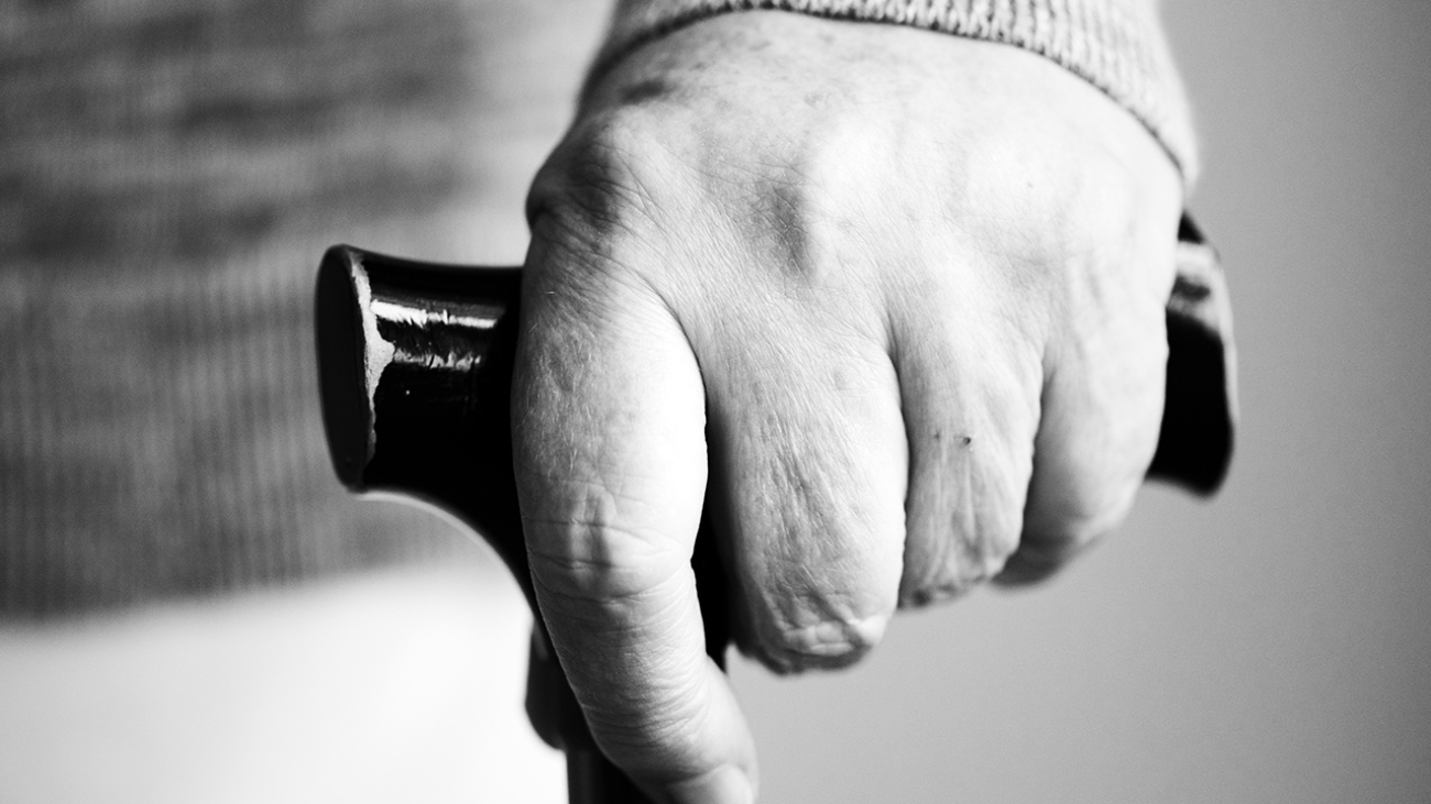 Closeup of elderly hand holding a walking stick